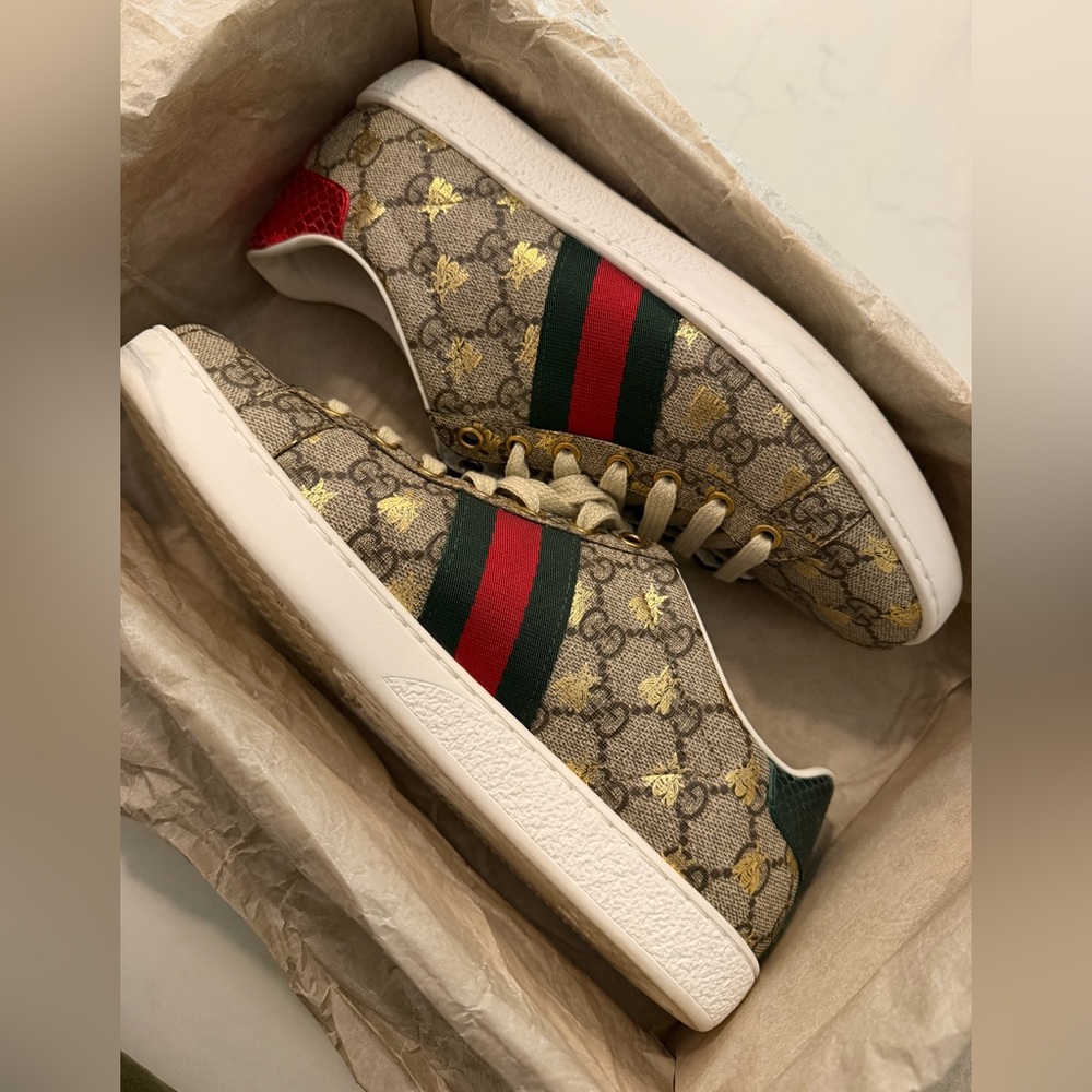 Women Gucci Ace sneakers in GG Supreme canvas with gold bee print.